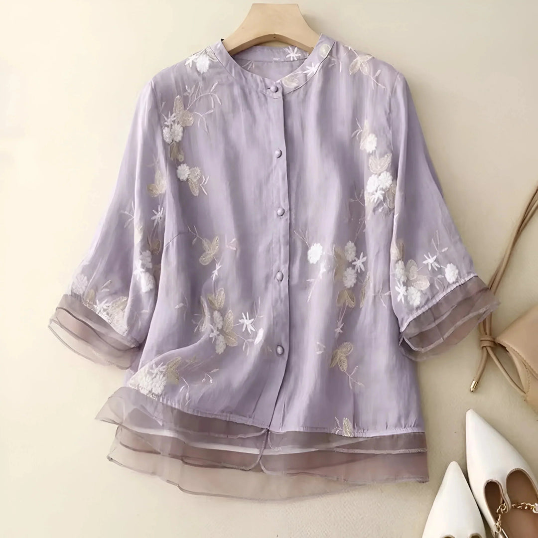 Blouse fluide femme décontractée à broderie florale. Col rond et détails boutons.
