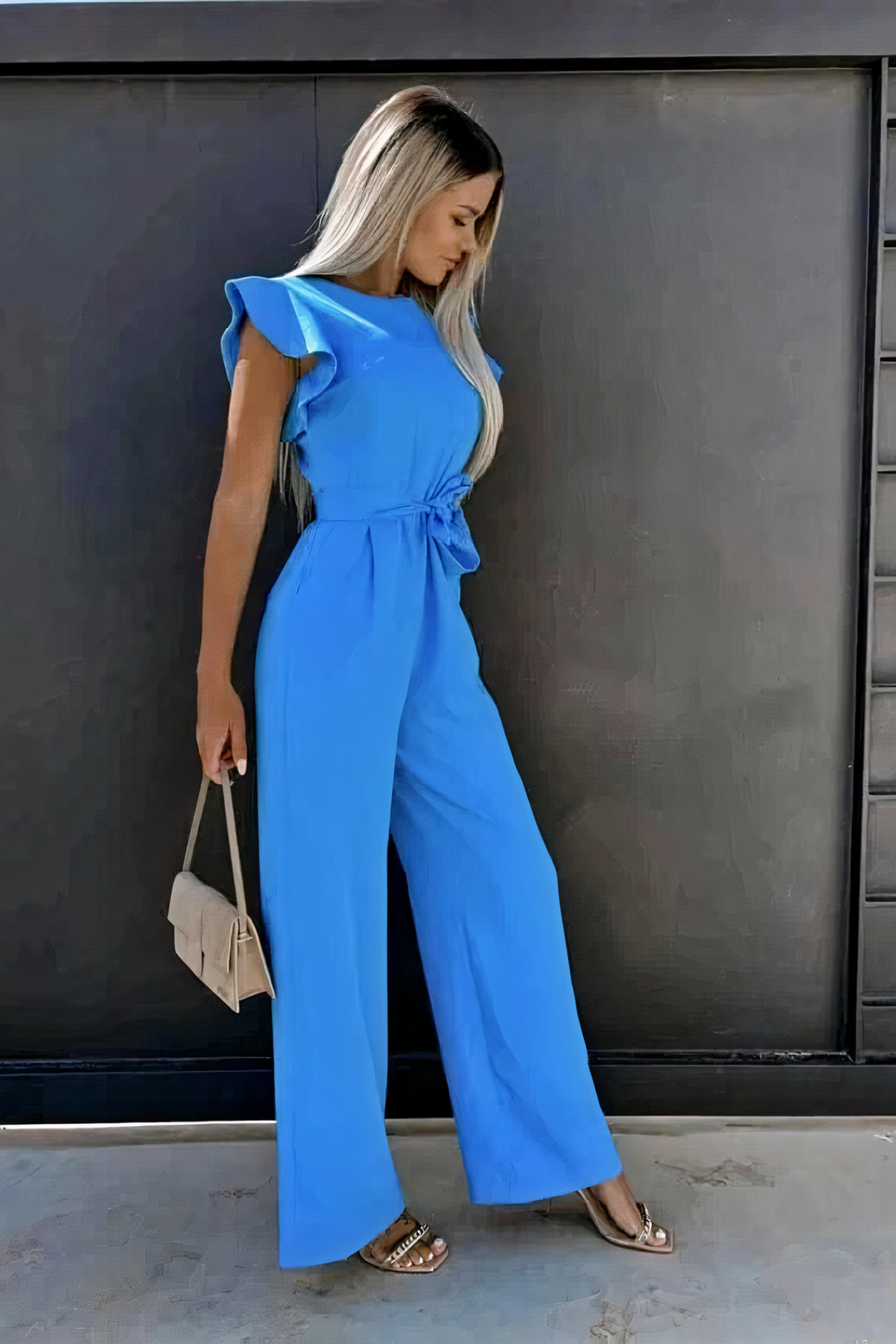 Jumpsuit femme sans manches, col rond, avec volants délicats et ceinture nouée, coupe jambes larges fluide.