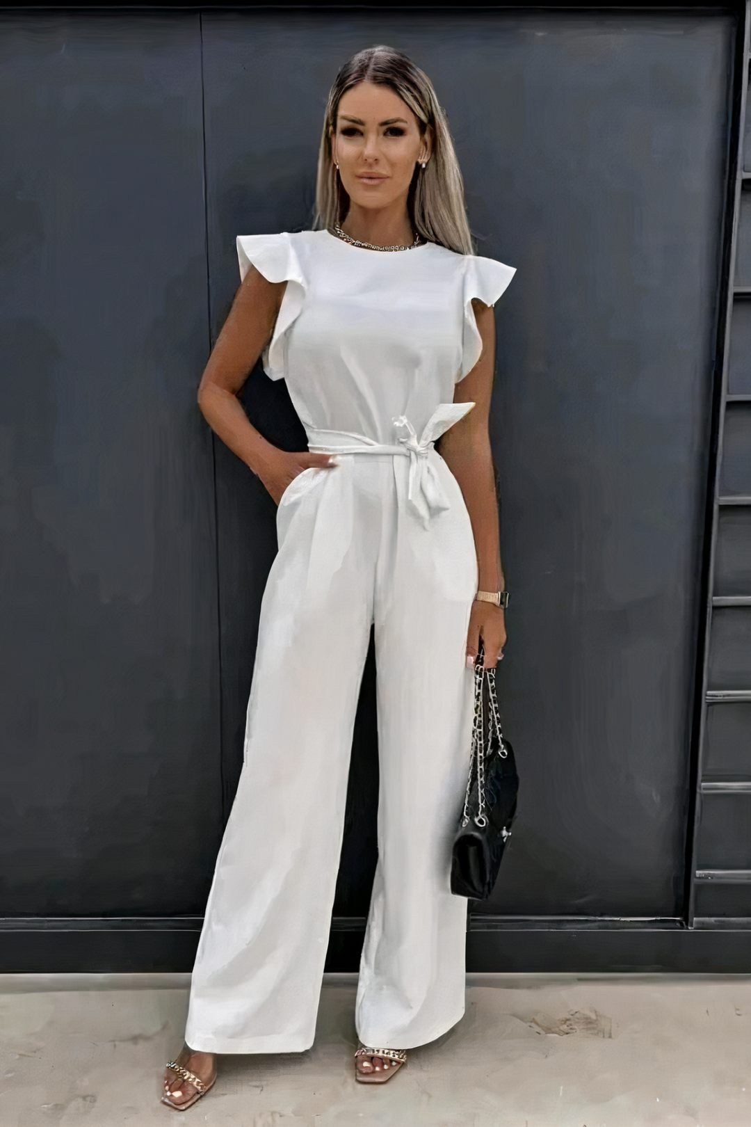 Élégante combinaison femme à volants et jambes larges, parfaite pour une tenue de soirée chic ou événement.
