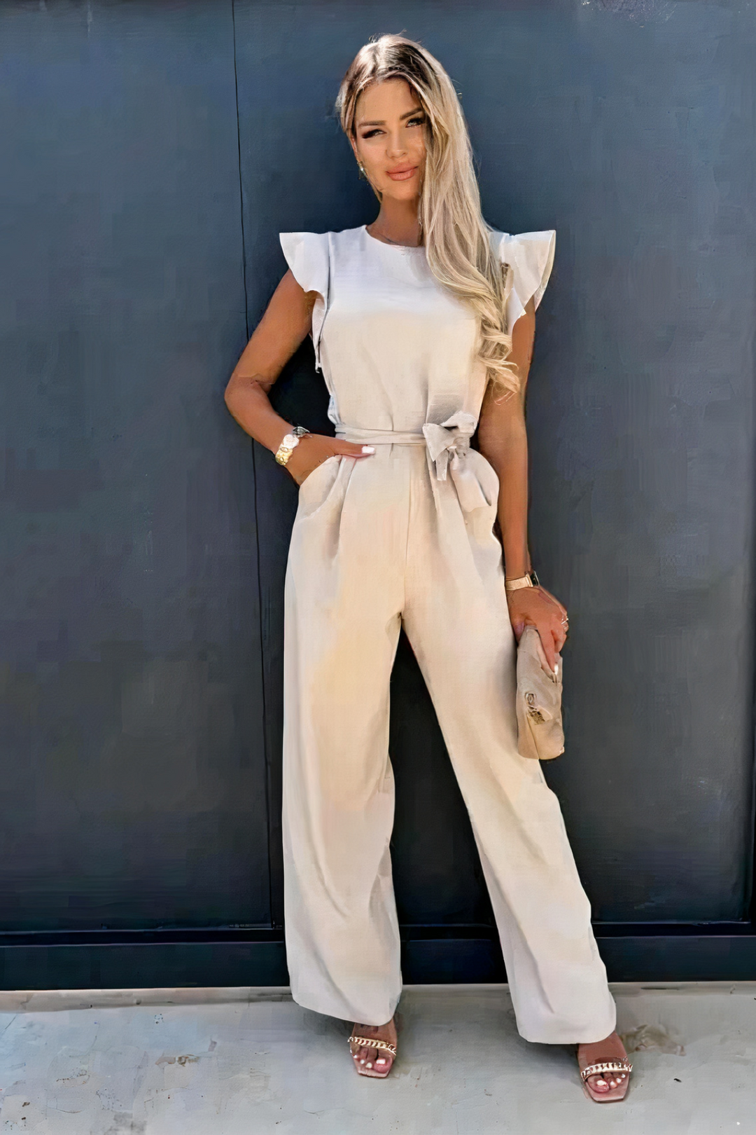 Combinaison femme élégante, sans manches, col rond, volants subtils, jambes larges pour un look moderne et fluide.