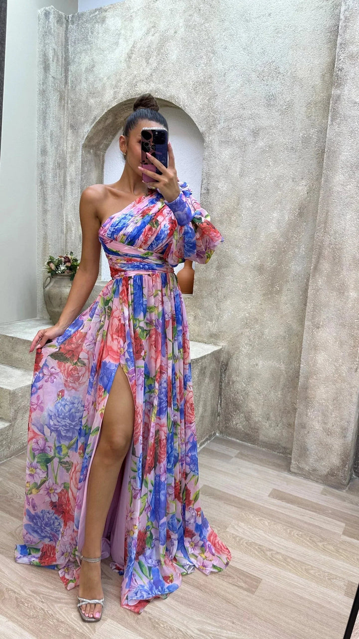 Robe longue femme asymétrique en tissu léger à motifs floraux. Fente et manches bouffantes pour l'été.