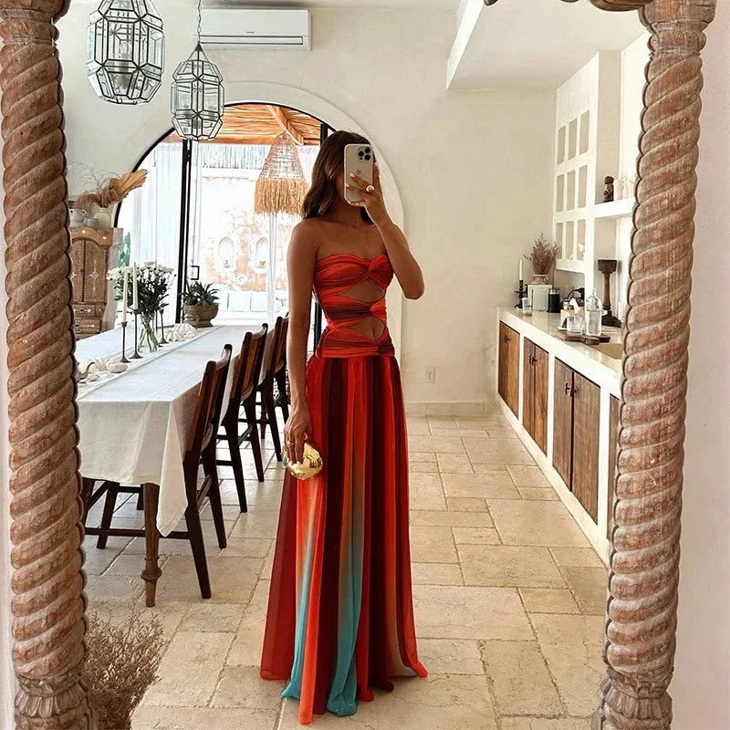 Élégante robe longue femme fluide, style bustier sans bretelles, avec découpes modernes et fente latérale pour soirée.