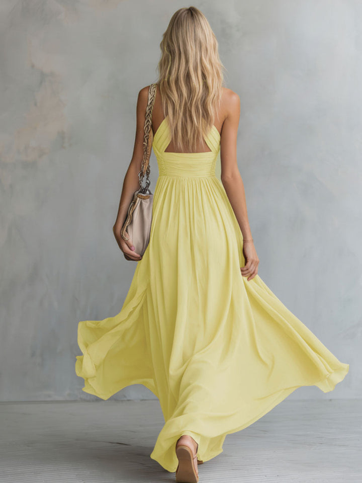 Robe longue femme jaune pour soirée, col halter et décolleté plongeant. Coupe A-ligne fluide et très élégante.