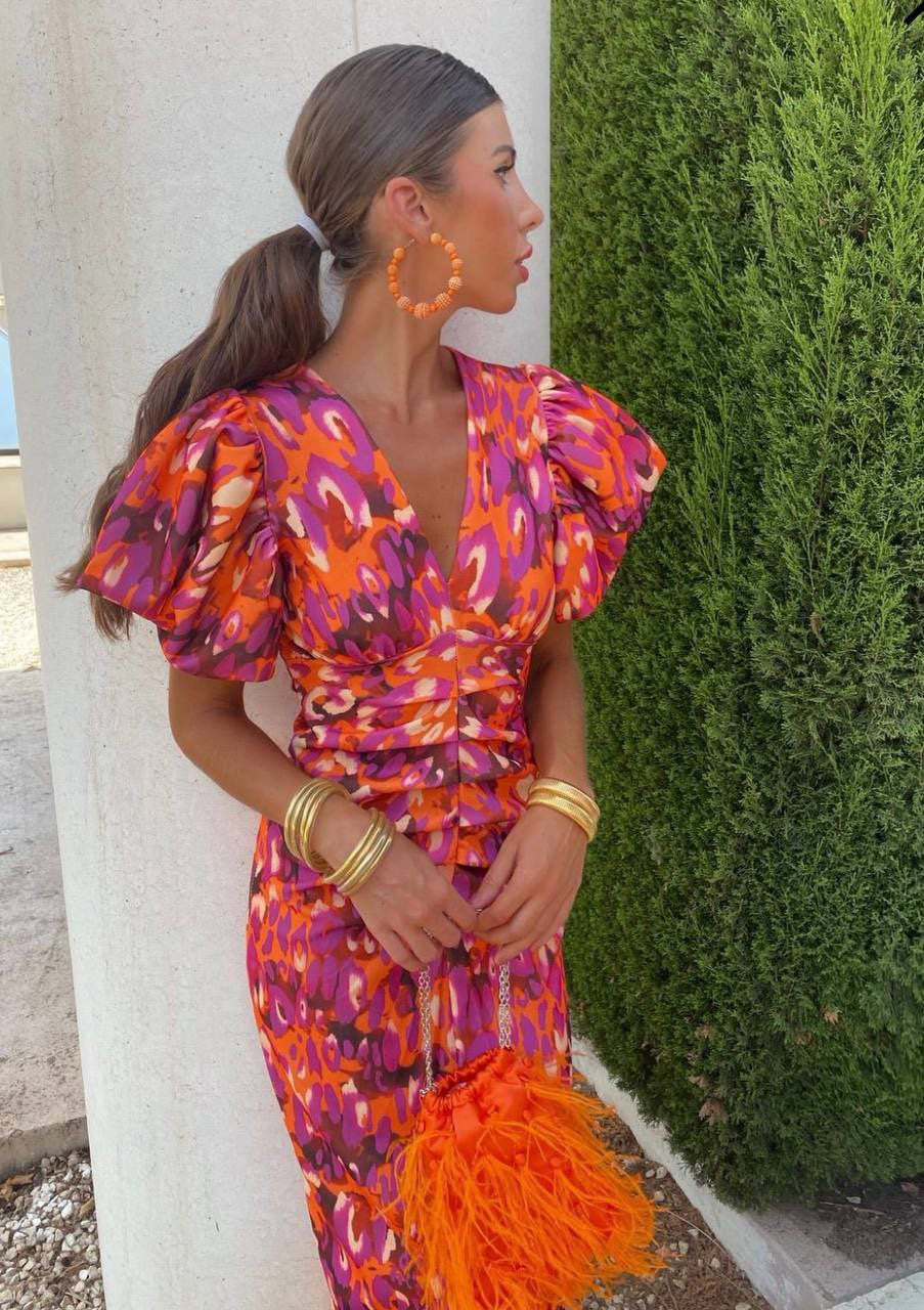 Tenue de soirée chic: robe midi léopard avec col V et manches bouffantes, parfaite pour l'été ou un cocktail.