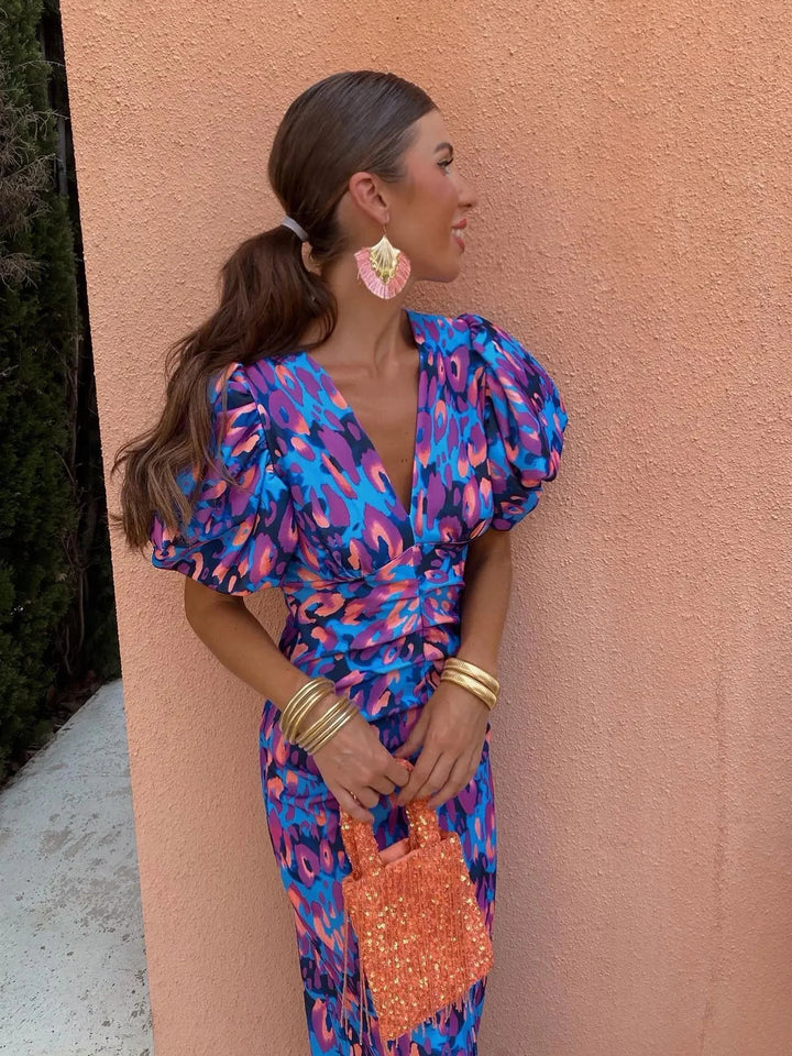 Robe midi féminine à motif léopard. Son col V profond et ses manches bouffantes apportent une touche de mode unique.