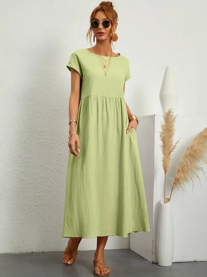 Robe femme, coupe midi ample, manches courtes, col rond, poches. Tendance et confortable.