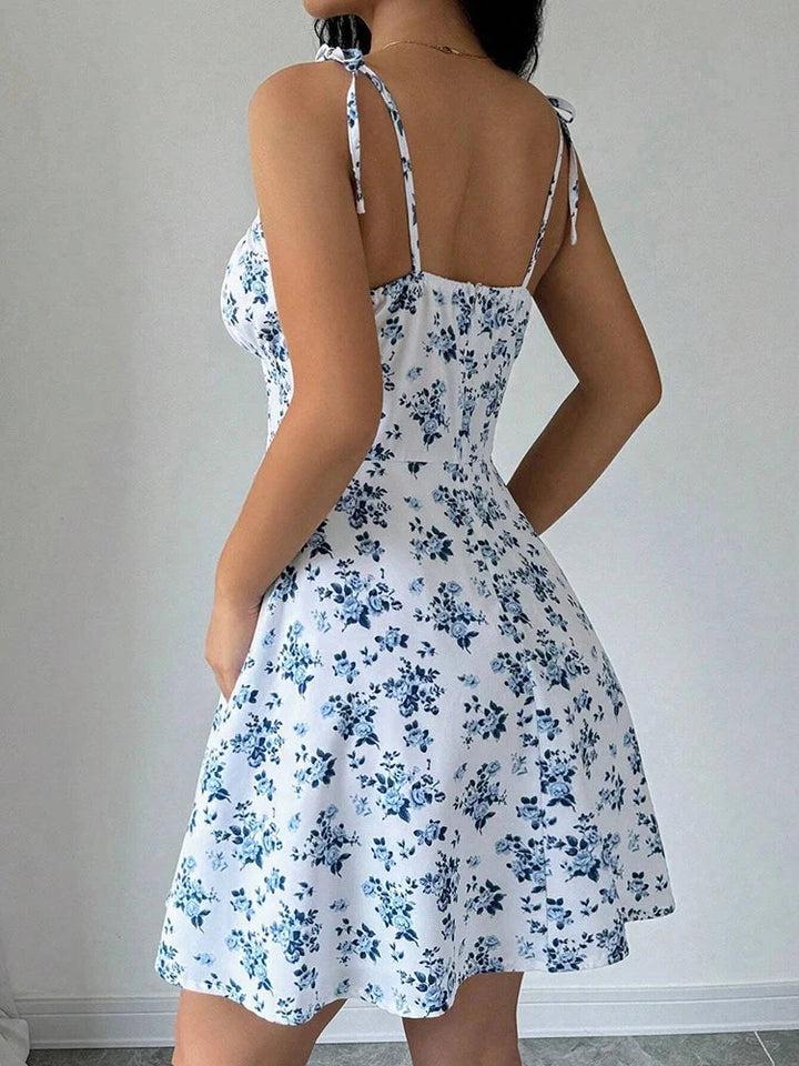 Robe courte fleurie femme. Col carré, bretelles nouées. Style décontracté et chic pour l'été à la plage.