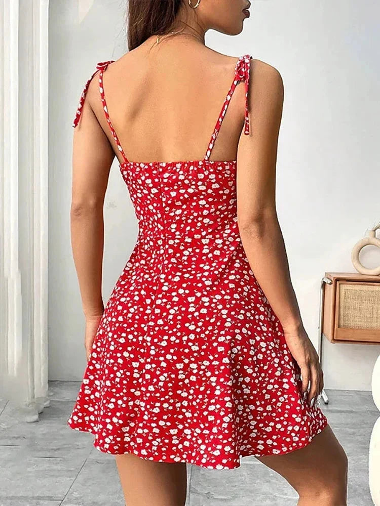 Robe trapèze mini fleurie femme avec col carré et bretelles nouées. Idéale pour un été féminin et léger.