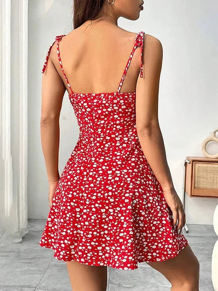 Robe trapèze mini fleurie femme avec col carré et bretelles nouées. Idéale pour un été féminin et léger.