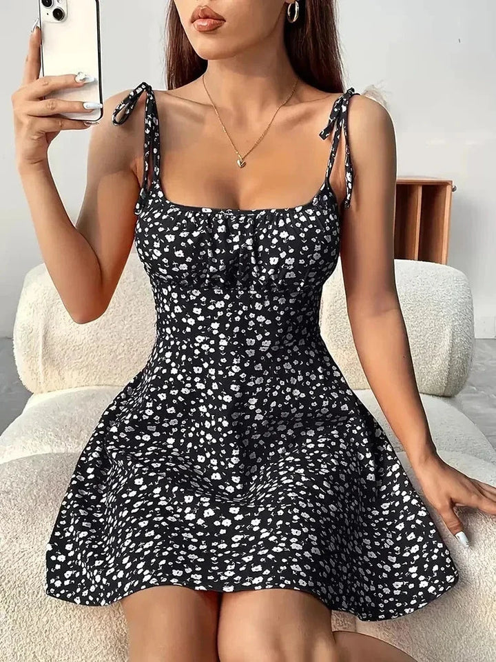 Robe femme fleurie, coupe mini, col carré. Bretelles nouées, jupe trapèze. Confort féminin pour l'été.