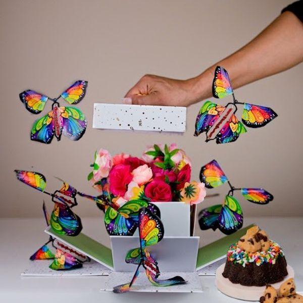 Papillons volants magiques s'échappant d'un coffret, idée cadeau original pour enfants et fêtes.