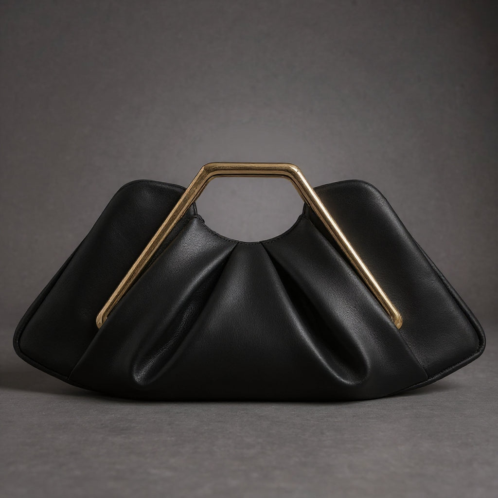 Détail de la poignée dorée sur la pochette de luxe La Courbe femme, design origami cuir et microfibre.