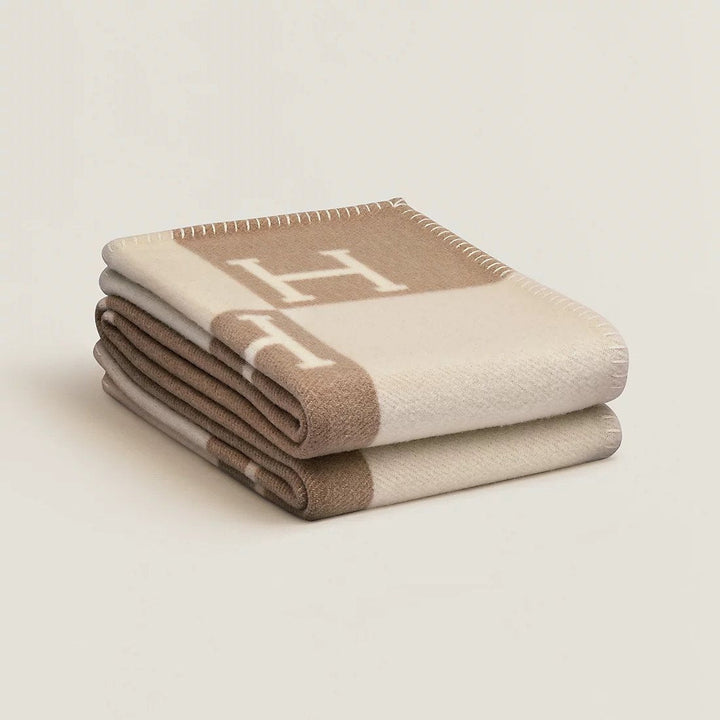 Texture douce et luxueuse d'un plaid en cachemire et laine, détail de confort hivernal.