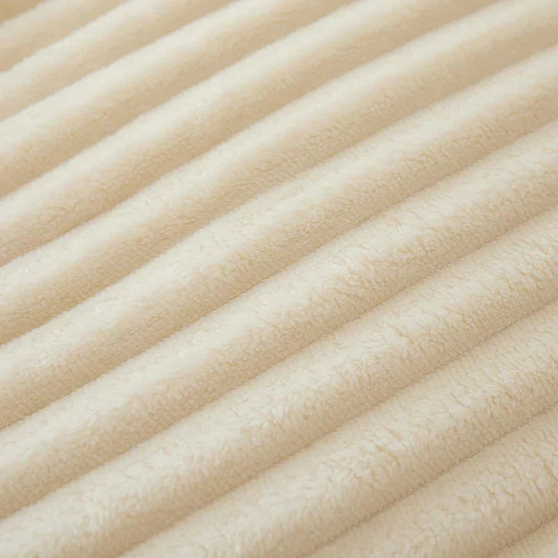 Créez une ambiance chaleureuse avec cette couverture polaire rayée, idéale pour les soirées d'hiver.