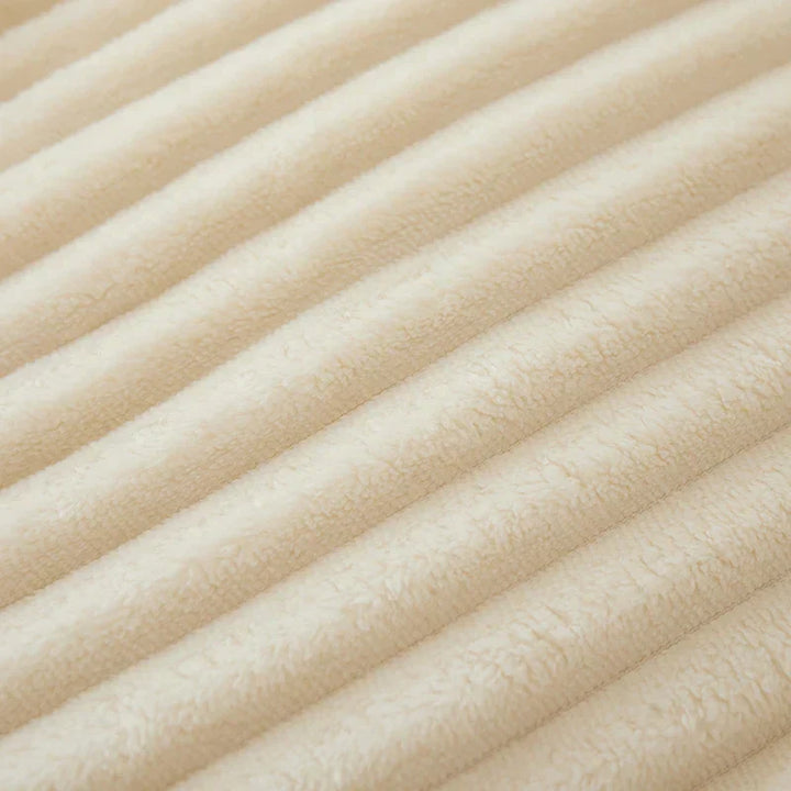 Créez une ambiance chaleureuse avec cette couverture polaire rayée, idéale pour les soirées d'hiver.