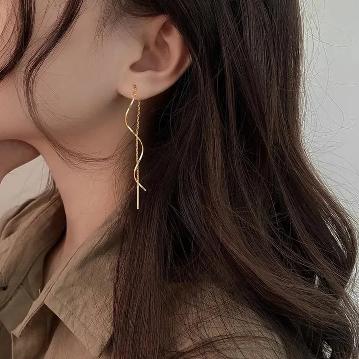 Design géométrique: boucles d'oreilles vagues longues, modernes et féminines, en argent poli.