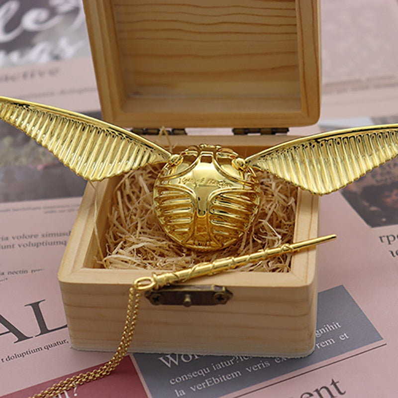 Coffret bijoux "Orb Ailée" doré, design unique avec sphère et ailes. Boîte à anneau luxe pour un rangement précieux.