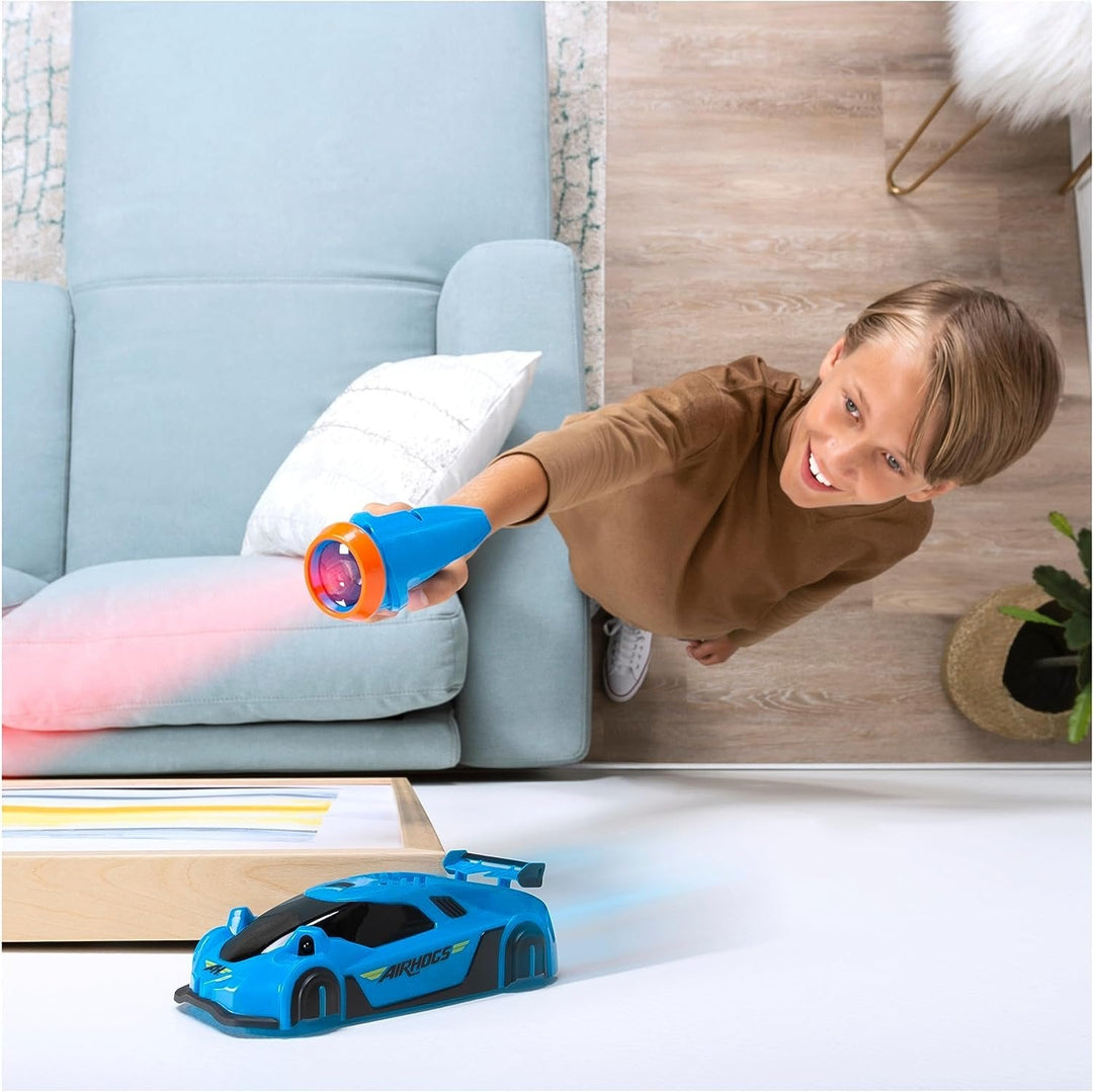 Enfant jouant avec une voiture télécommandée anti-gravité laser sur un mur, expérience RC unique.