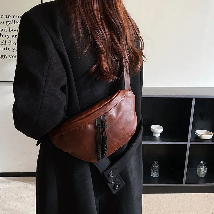 Gros plan sur sac banane femme en similicuir marron, texture lisse, détail chic et tendance.
