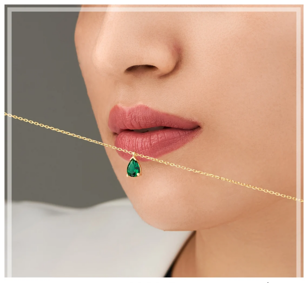 Collier femme avec pendentif goutte d'émeraude et strass. Bijou précieux et élégant pour toute occasion.