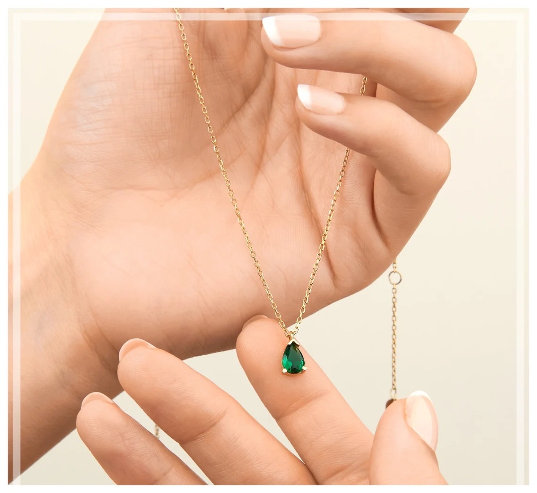 Pendentif collier femme précieux, goutte d'émeraude scintillante sertie de strass. Élégant accessoire de mode.