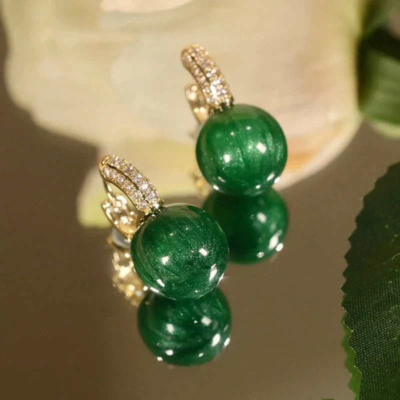 Boucles d'oreilles à perles vertes rondes pour femme, un bijou classique et élégant en argent doré.