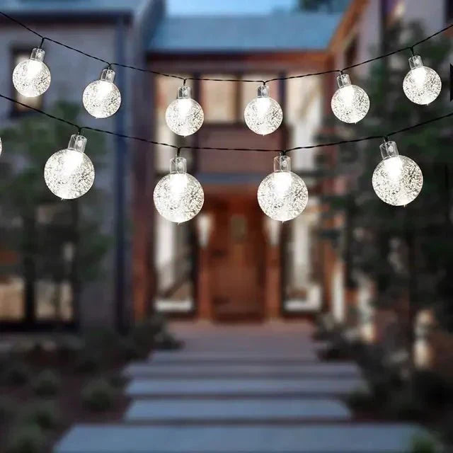 Lumière extérieure LED solaire créant une ambiance chaleureuse et festive pour terrasse, jardin.