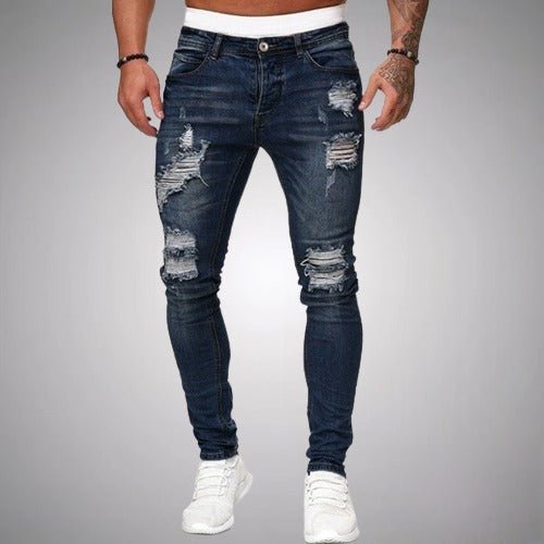 Gros plan sur un jean slim fit homme déchiré en denim bleu, soulignant son style polyvalent et sa coupe mode.