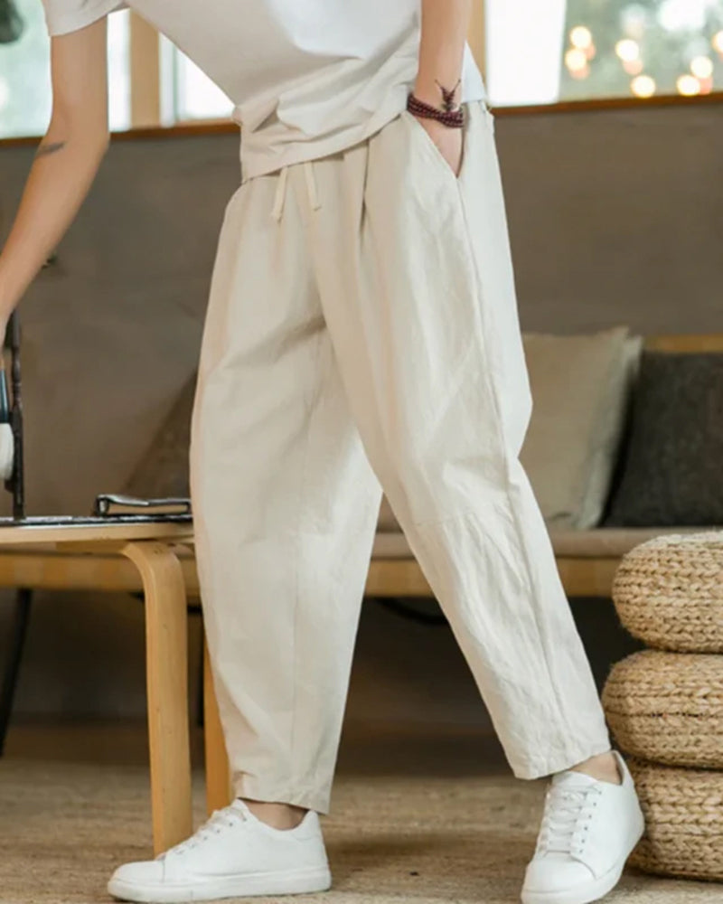 Pantalon homme ample et décontracté à plis. Taille élastique pour un confort optimal et un style casual moderne.