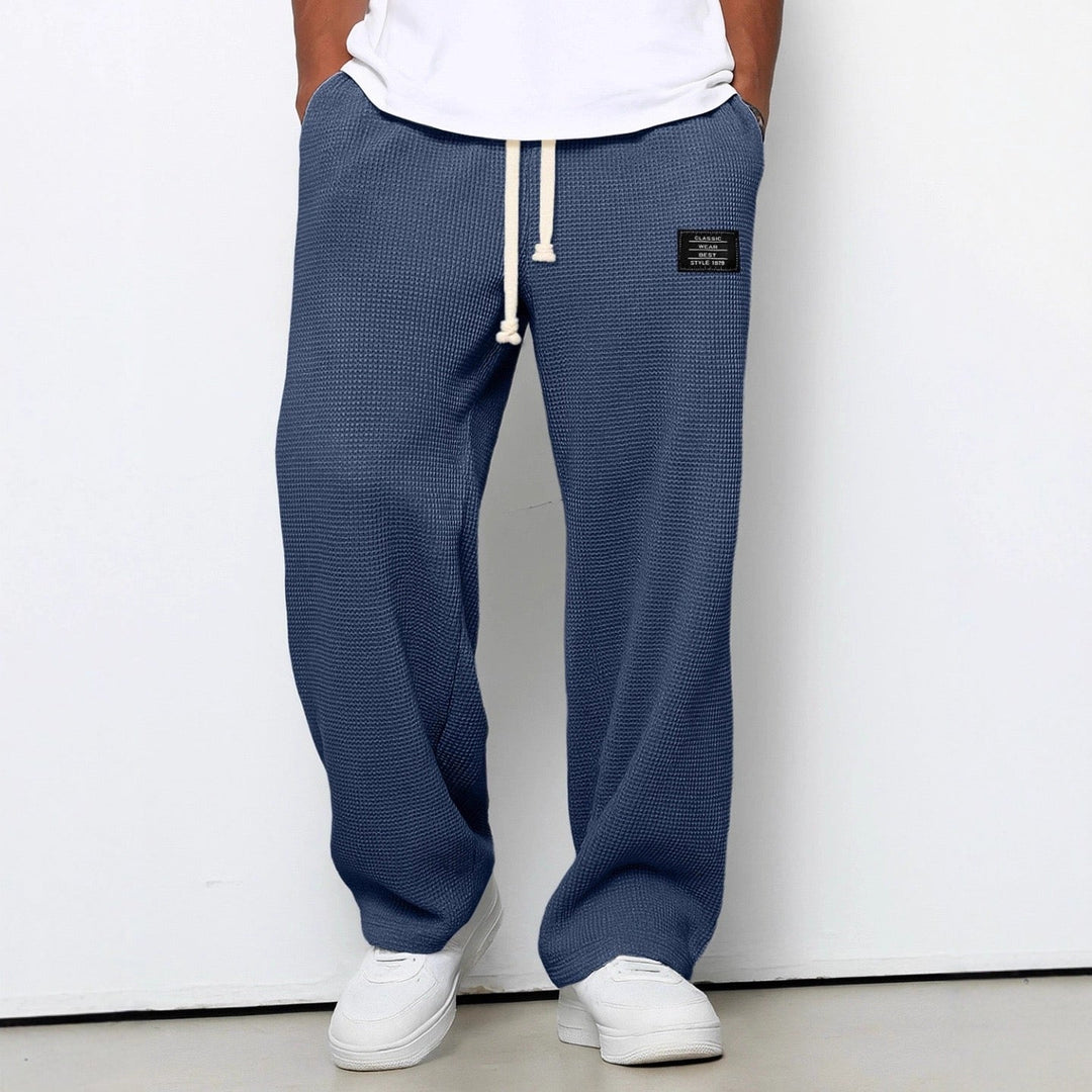 Pantalon jogging homme gris chiné, coupe droite, offrant un confort décontracté. Idéal pour un style moderne et polyvalent.