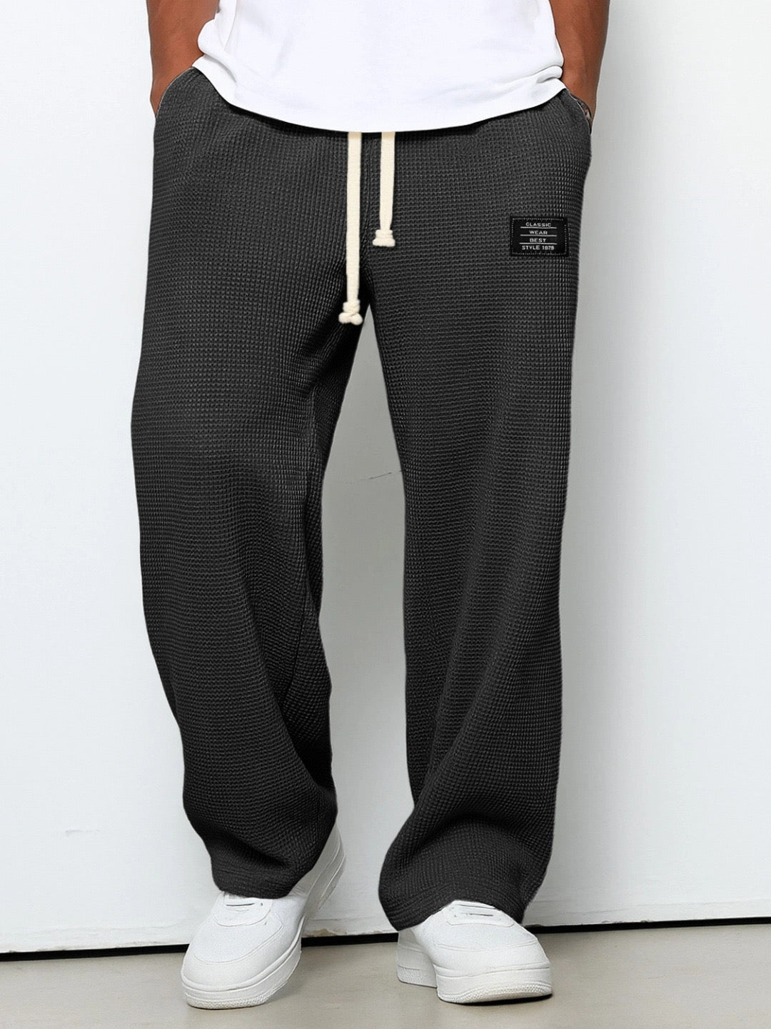 Homme portant un pantalon jogging droit noir, look moderne et décontracté, parfait pour le confort quotidien et le streetwear.