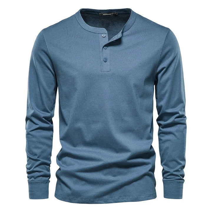 Modèle homme portant un t-shirt Henley gris, manches longues, coupe droite. Idéal pour un look quotidien chic.