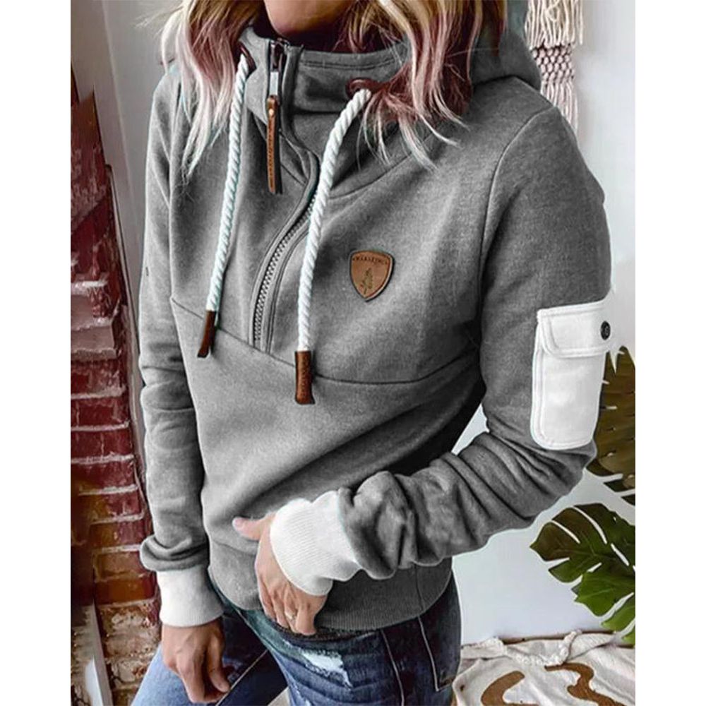 Femme souriante portant un pull à capuche Aarohi, confort décontracté. Idéal pour le style automne-hiver.