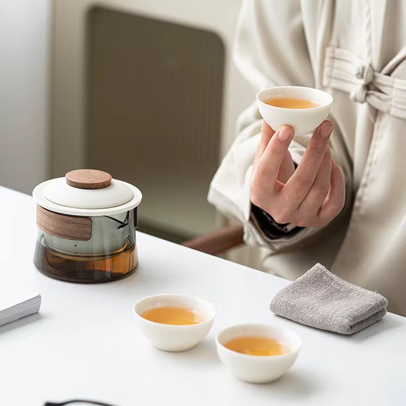 Set de thé portable en céramique et verre, incluant infuseur et tasses, idéal pour bureau et voyage.