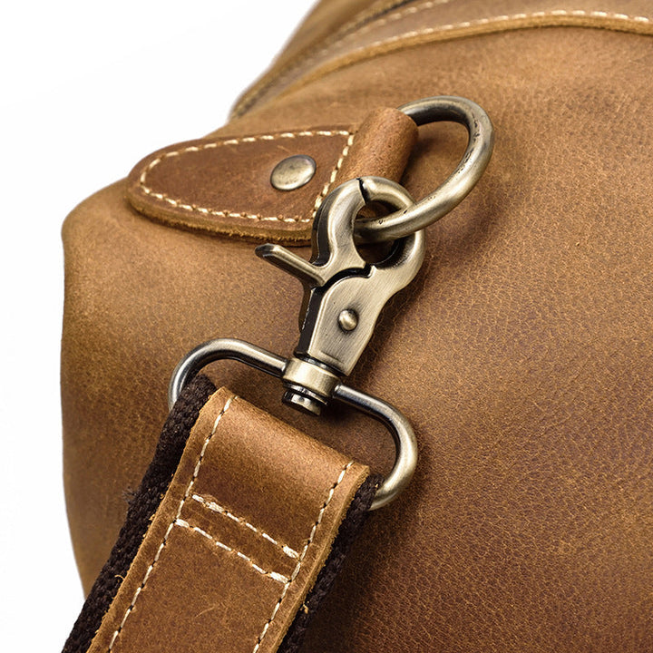 Sac duffel de voyage homme en cuir marron vintage, vue latérale, montrant sa grande capacité.
