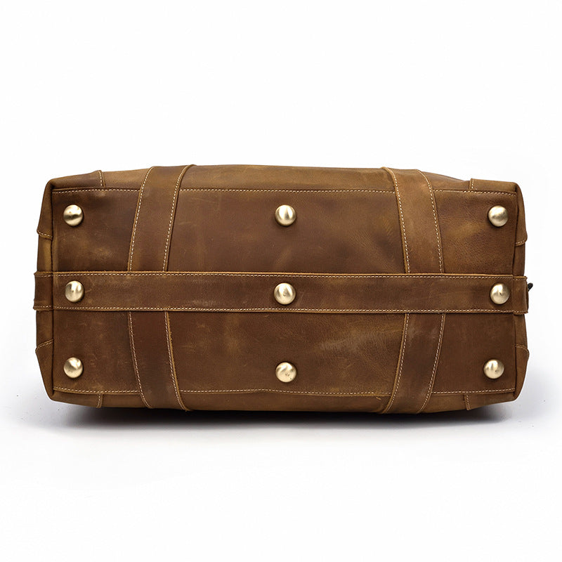 Texture du cuir marron vintage d'un sac duffel de voyage homme, accent sur l'authenticité.