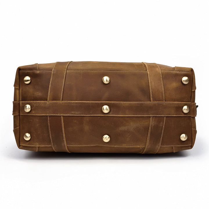 Texture du cuir marron vintage d'un sac duffel de voyage homme, accent sur l'authenticité.