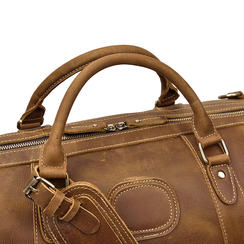 Sac de voyage homme en cuir marron, style duffel vintage, prêt pour l'aventure. Grande capacité.