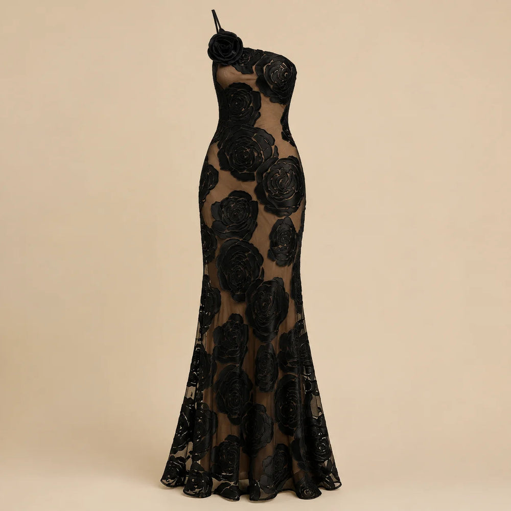 Maxi robe femme chic et asymétrique, ornée d'une fleur. Idéale pour un événement, une soirée élégante ou un cocktail.