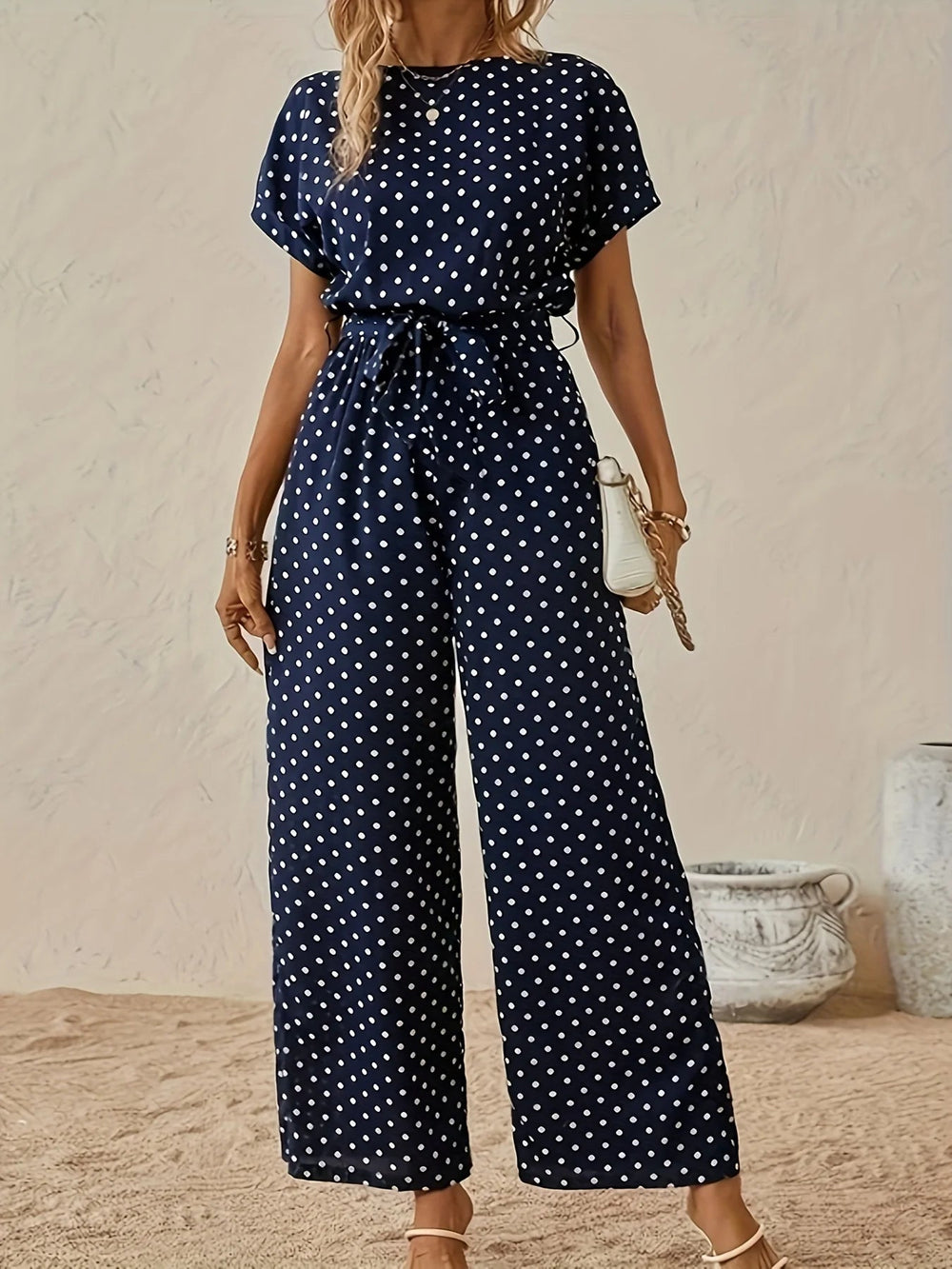 Jumpsuit femme chic à pois, taille haute, coupe large fluide. Parfaite pour l'été, look décontracté et élégant.