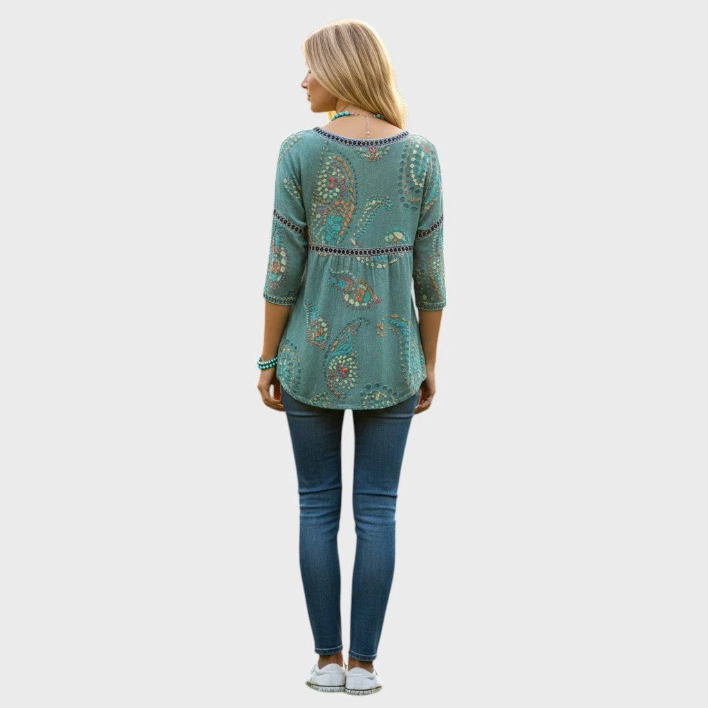 Gros plan sur le motif floral 3D délicat d'un top femme blanc à encolure ronde.
