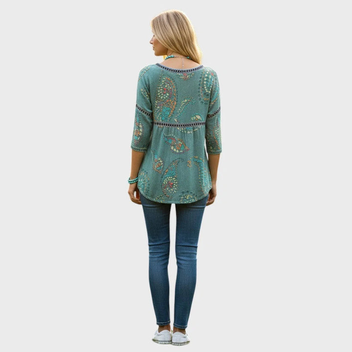 Gros plan sur le motif floral 3D délicat d'un top femme blanc à encolure ronde.