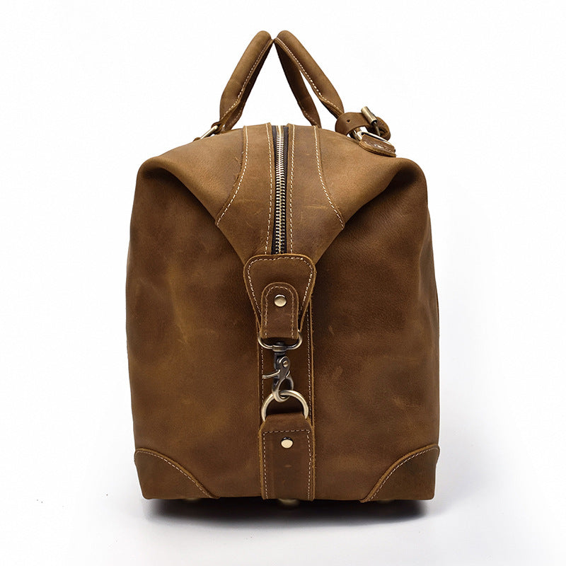 Robuste sac duffel de voyage homme en cuir marron vintage, grande capacité pour toutes les aventures.