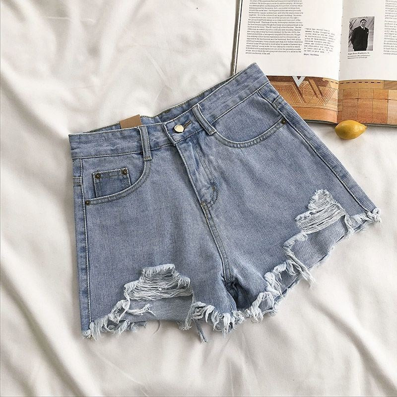 Short femme jean taille haute, coupe large. Ourlets bruts et effet usé, style moderne et casual d'été.
