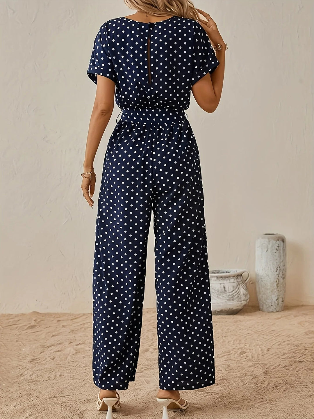 Combinaison femme à pois ceinturée, coupe large fluide pour un confort élégant. Style chic printemps-été décontracté.