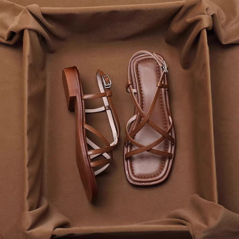 Vue latérale d'une sandale plate femme rétro, bout ouvert et brides croisées, chaussure élégante pour l'été.