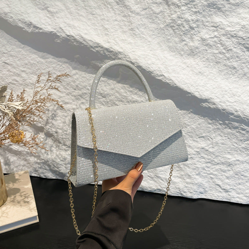 Sac femme pochette soirée, design effet diamant brillant. Accessoire de luxe noir compact et moderne.