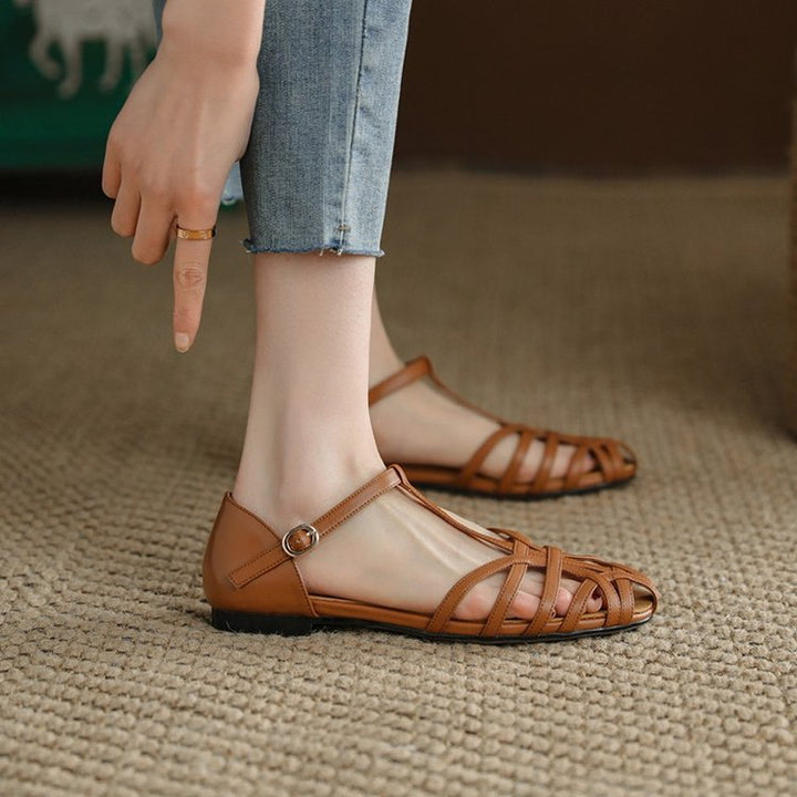 Sandale femme plate estivale rétro avec motif ajouré. Élégante et confortable, idéale pour la mode décontractée.