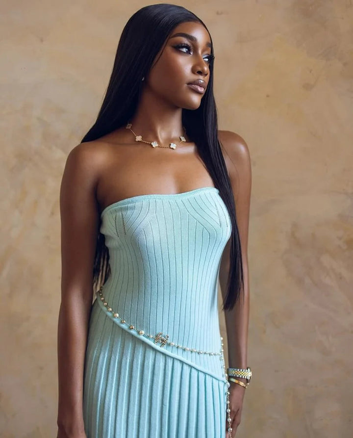 Robe de soirée longue femme sans bretelles bleu clair, bustier fleur torsadée et jupe ample plissée élégante.