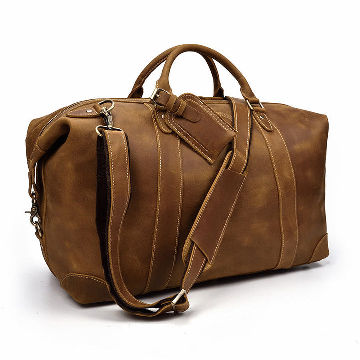 Sac de voyage homme en cuir marron, style duffel vintage. Bagage robuste et pratique pour escapades.
